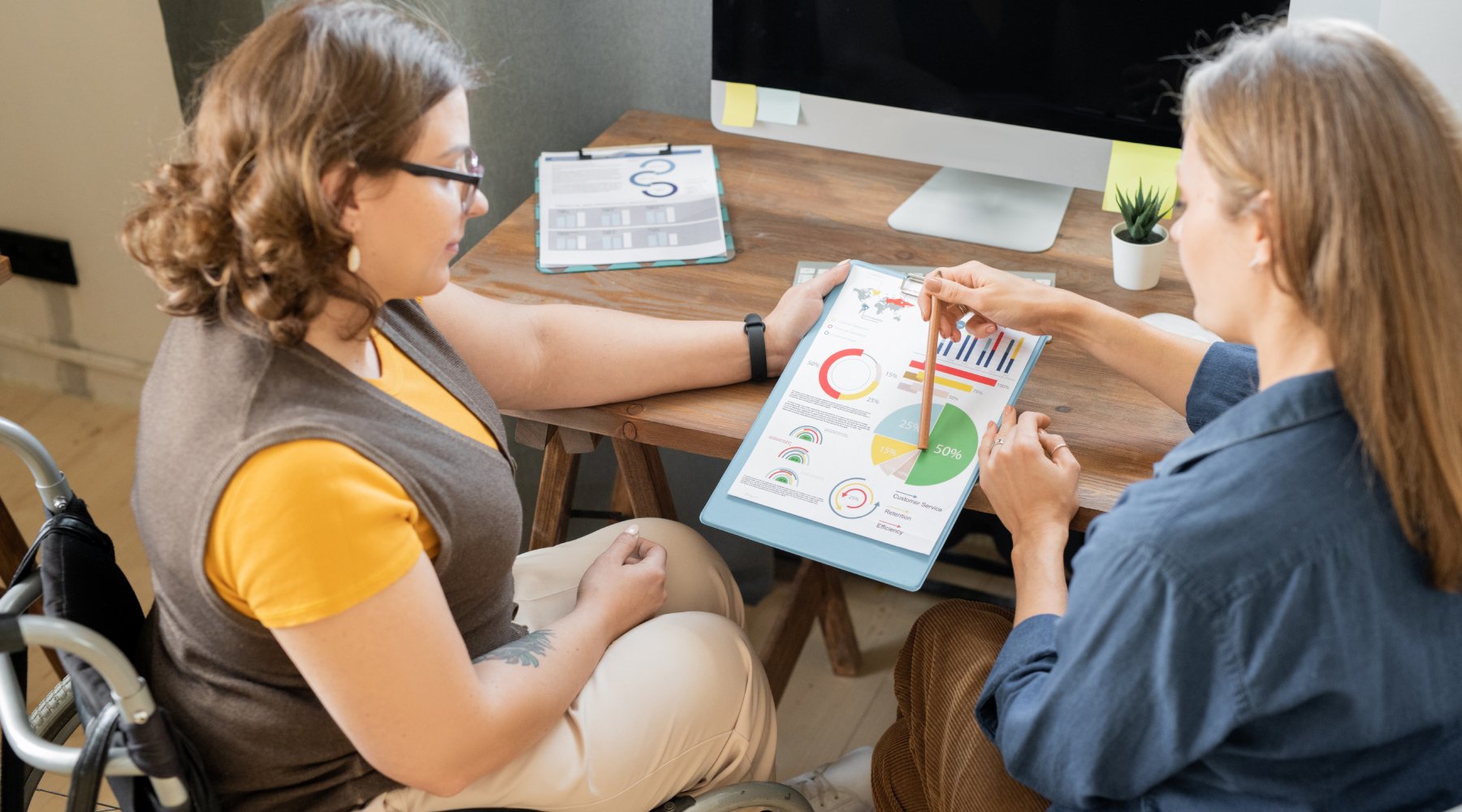 diagrams while one of them pointing at data and explaining it